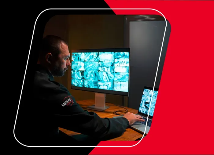 Rangers Security officer monitoring surveillance screens, emphasizing 24-hour security service.